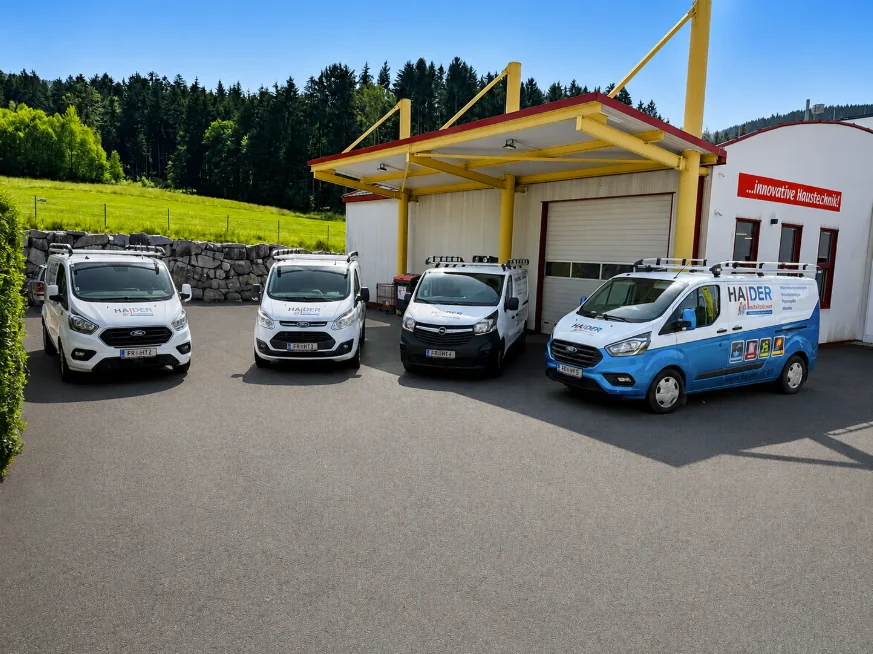 Unser Betriebsstandort mit vier Haider-Firmenfahrzeugen vor der Werkstatt