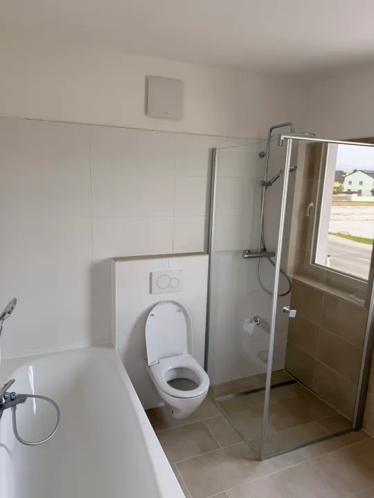 Helles Bad mit Badewanne, WC und Glasdusche