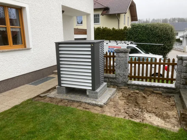 Wärmepumpen-Außengerät neben einem Wohnhaus