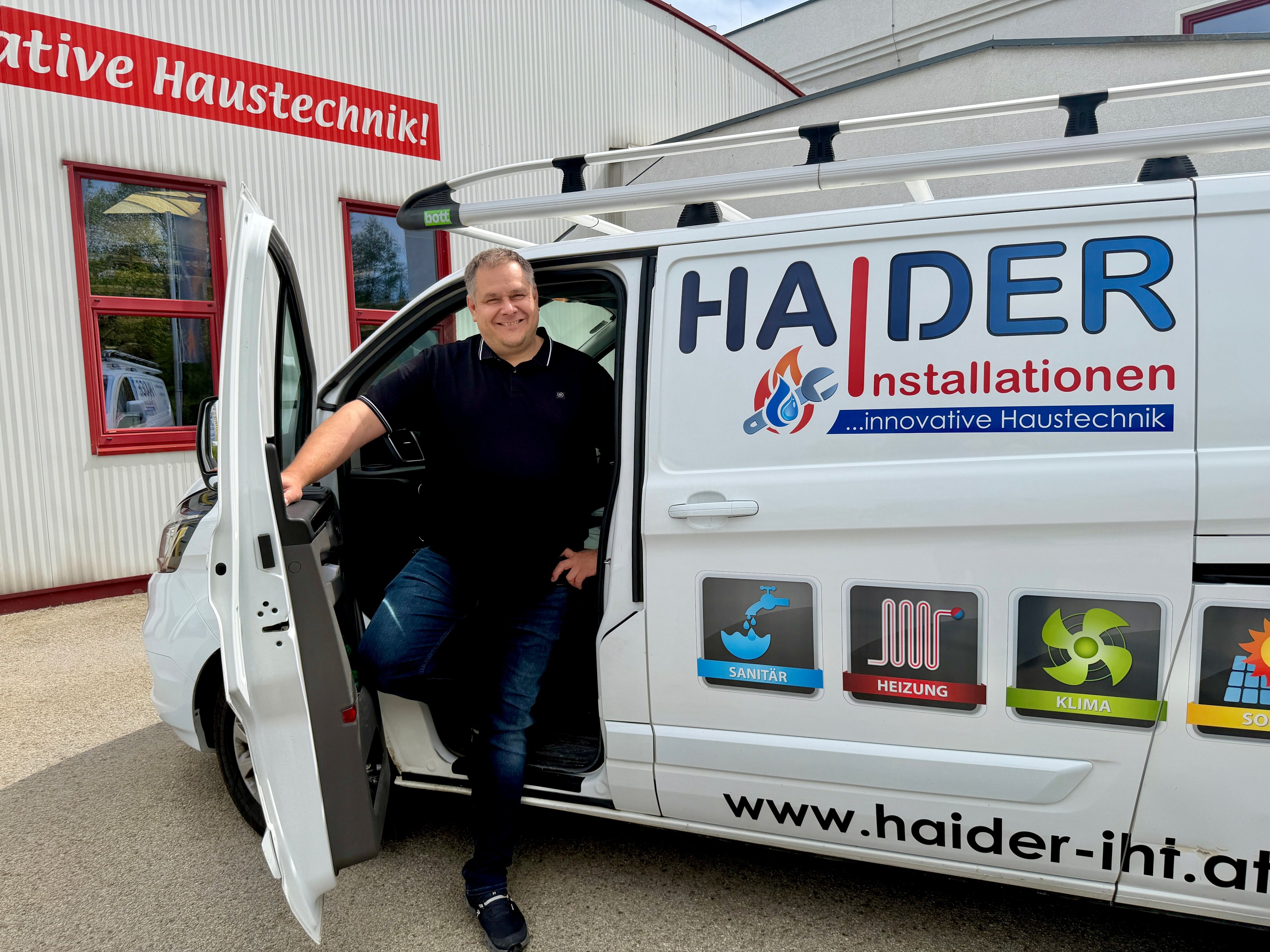 Chef der Firma Haider vor einem Firmenbus